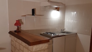 A compact kitchen with a gas stove, a sink, and a small countertop. - Type F2 apartment in a quiet country setting (Comps)