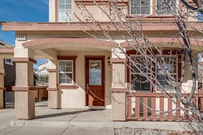 Stucco building with an arched entryway and a small porch.