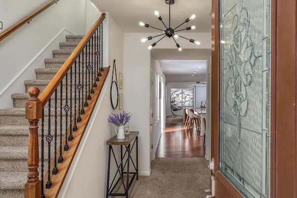 Staircase leads to a dining area with a wooden table and chairs.