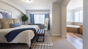 A bedroom with a large bed, a bedside table, a chair, a mirror, and a window with curtains. - Heber House, 20 min to Park City! Close to downtown Heber. (Heber City)