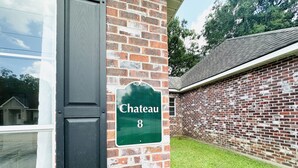 A brick building with a sign reading "Chateau 8" on a wall. - Chateau 8, spacious townhouse in Tickfaw, LA (Tickfaw)