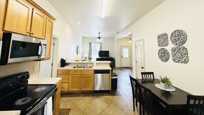 A modern kitchen with wooden cabinets, a central island, and stainless steel appliances. - Chateau 8, spacious townhouse in Tickfaw, LA (Tickfaw)