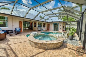 Uma área externa coberta com hidromassagem, assentos e piscina.