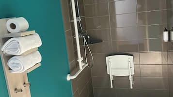 Une salle de bain moderne équipée d’une douche, de toilettes et d’un porte-serviettes avec des serviettes.