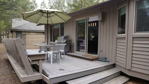 A small cabin with a deck, outdoor seating, and a grill. - Updated 2bd/2ba. Walk to Village, dog friendly, SHARC passes. (Sunriver)