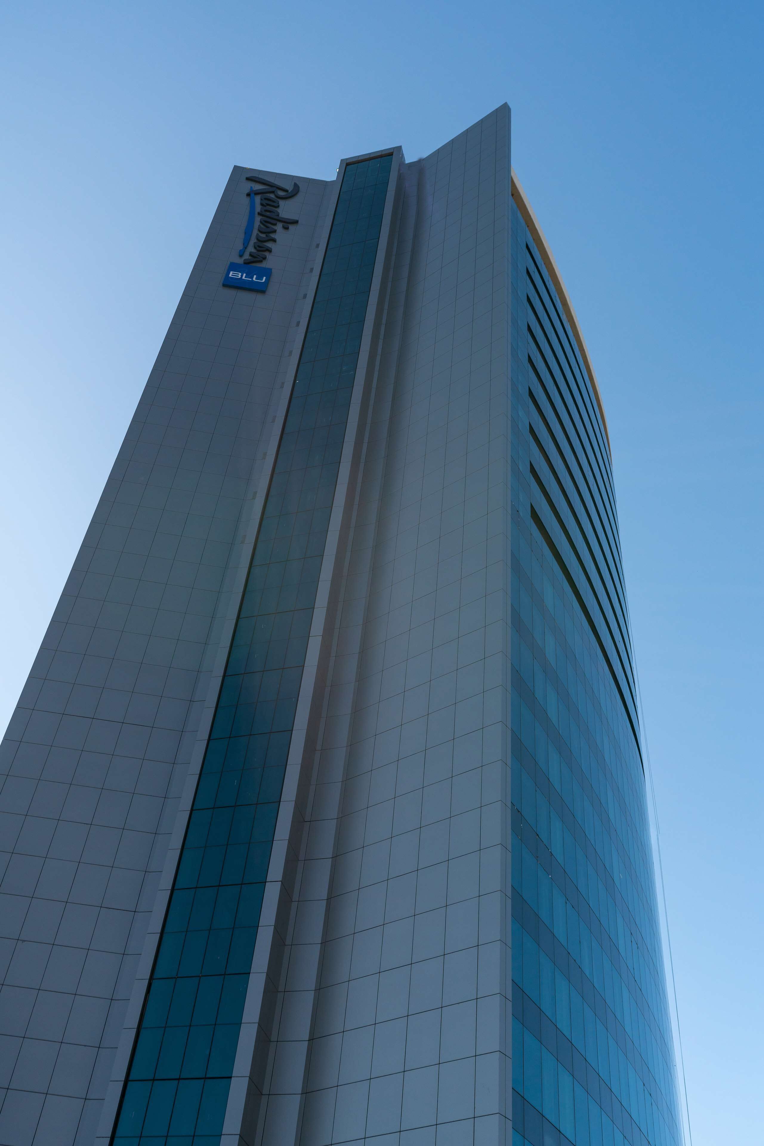 A tall, modern building with a prominent sign reading "Radisson Blu".