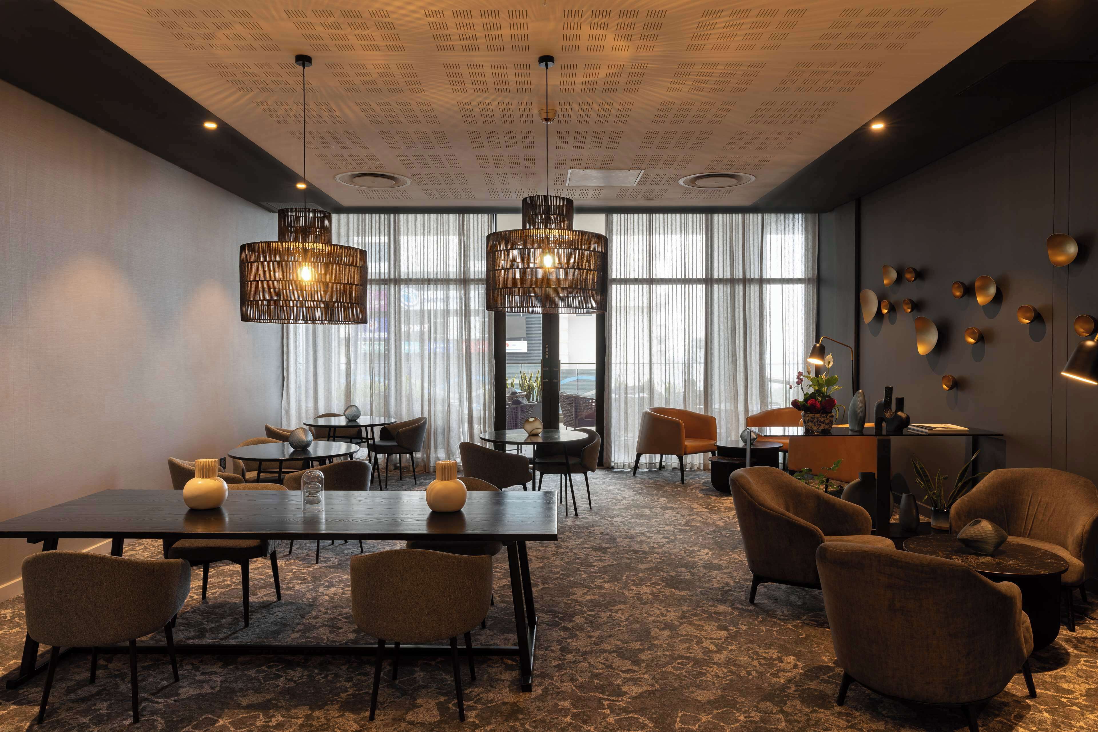 A modern conference room with a large table, several chairs, and a seating area with sofas.