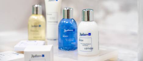 A bathroom shelf with various skincare products including lotions and body care items.