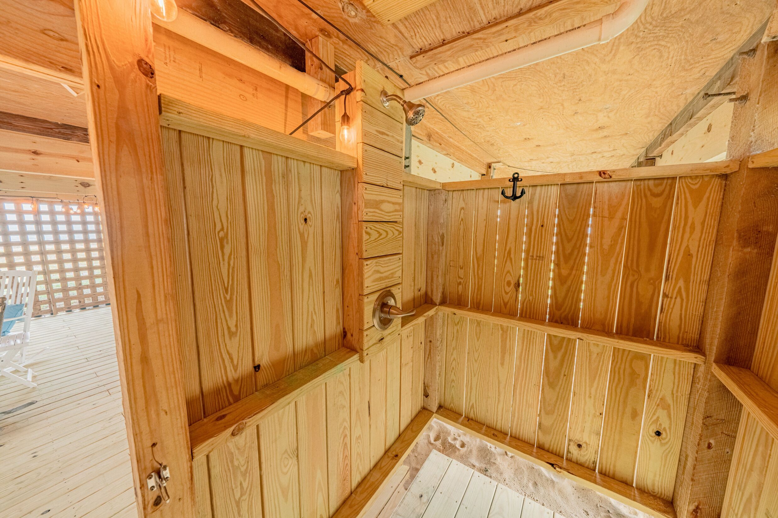 Eine Holzsauna mit Tür, Sitzbank und Handtuchhalter.