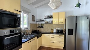Una cocina equipada con microondas, horno, pileta y refrigerador de acero inoxidable.