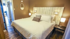 A neatly made bed with a wooden headboard, two bedside lamps, and a small bedside table with a lamp. - Lovely Lake Hamilton Condo, 1BR, Main Channel with an AMAZING VIEW! w/ boat slip (Hot Springs)