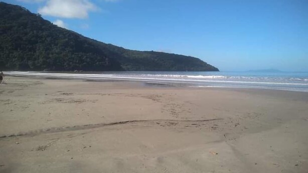 A beach with a clear sky and a mountain in the background. - HOTEL NEVADA (Ubatuba)