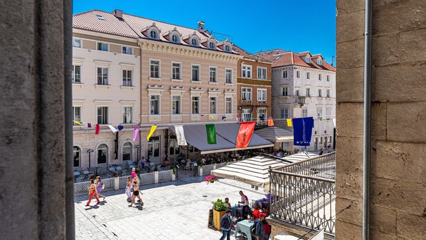 A public square with historic buildings, outdoor seating, and people walking. - Pjaca City Rooms (Split)