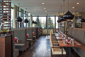 A restaurant with high ceilings, large windows, and a long dining table set with glasses and cutlery. - Haynie’s Hidden Getaway- 9mins from ATL airport! (Forest Park)