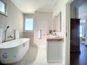 Een bad/douchecombinatie, een haardroger, handdoeken