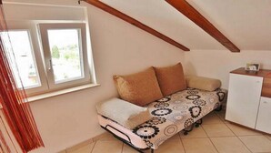 Una habitación pequeña y acogedora con cama, ventana y armario.