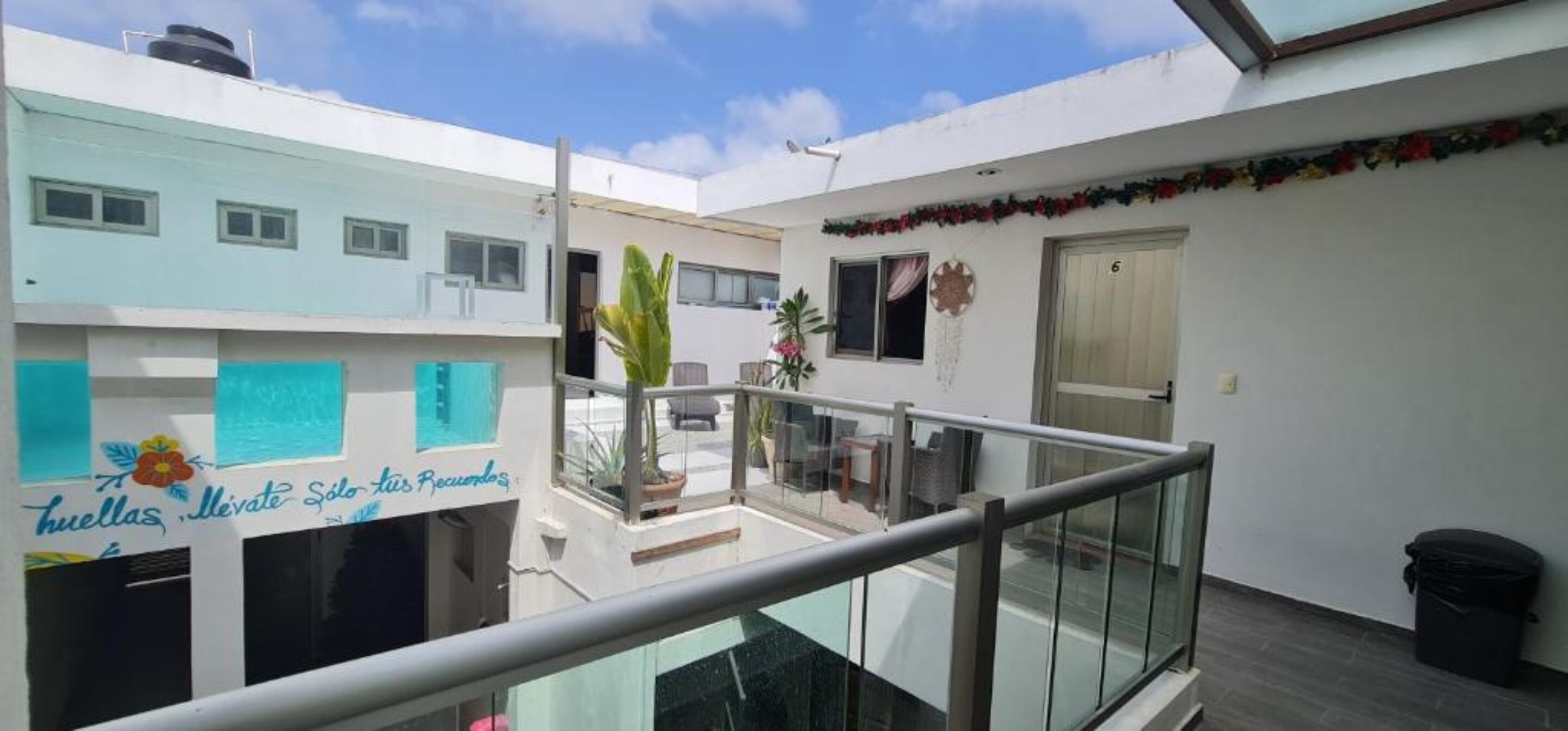 A residential building with a balcony, a small patio area, and a door marked with the number 6.