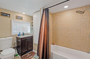 Un baño con inodoro, lavamanos, tocador, ducha y bañera.