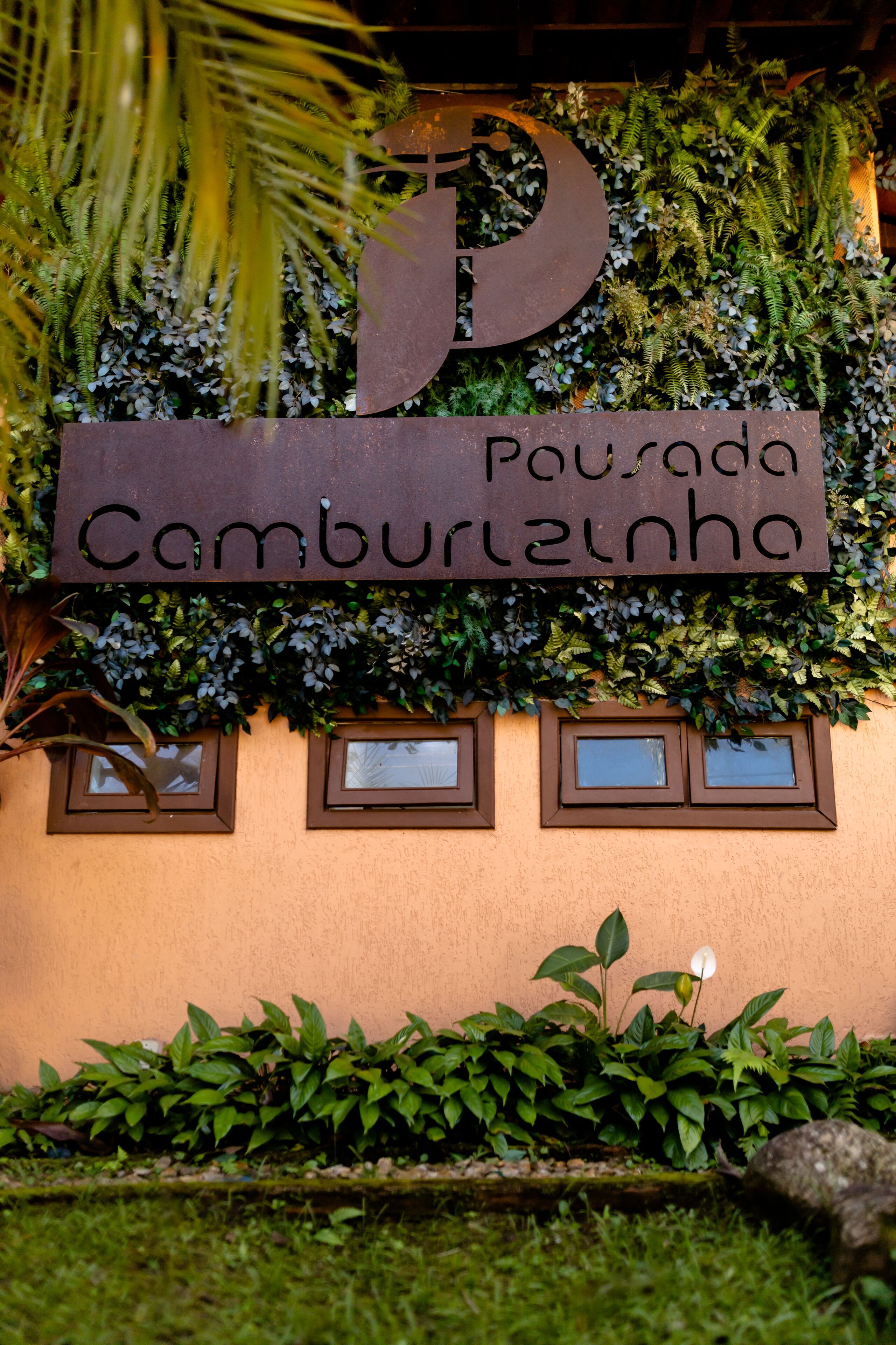 A sign with the letter 'P' and the words 'Pousada Camburilha' indicating a lodging establishment.