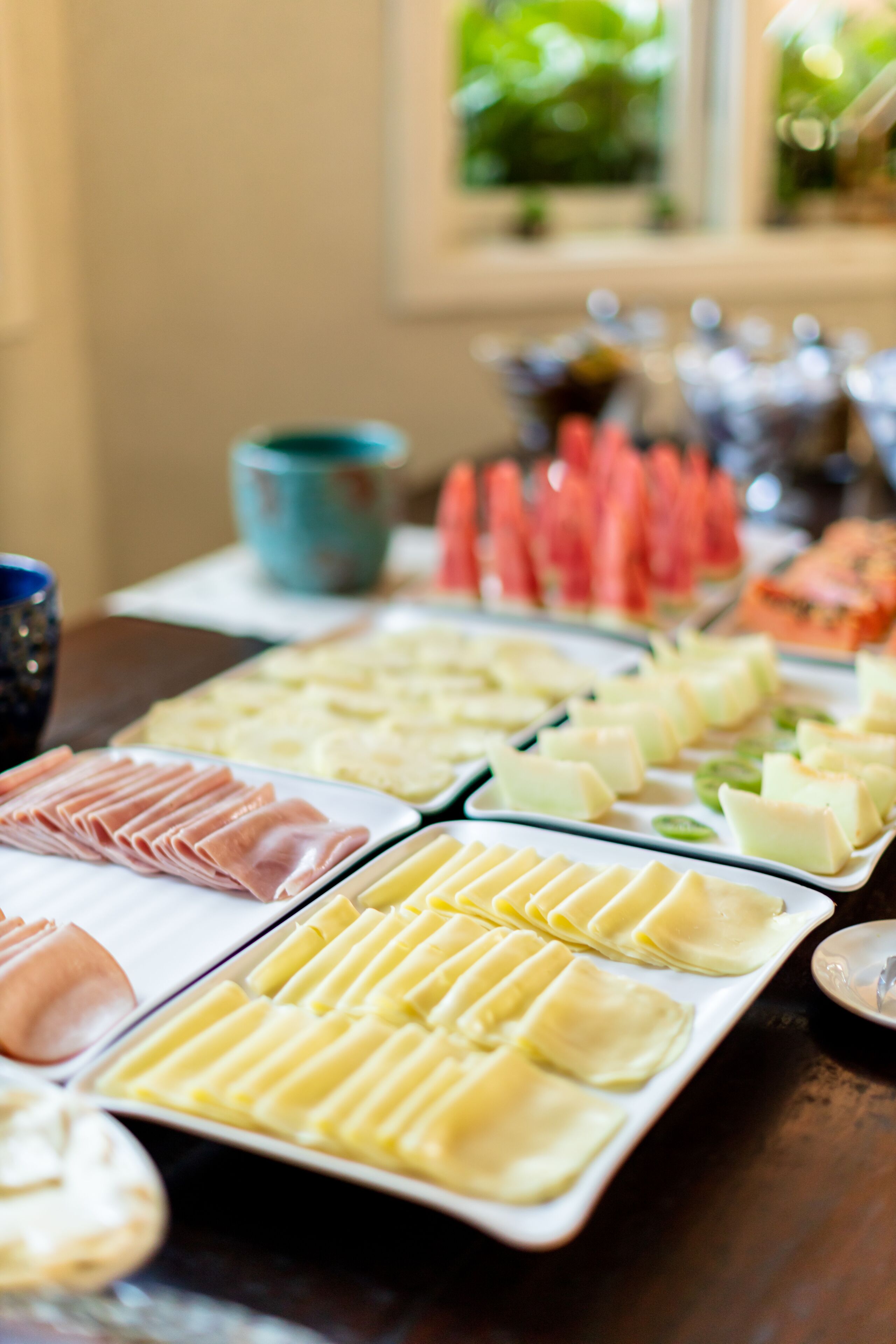 Un bufé con diversos alimentos, incluyendo carnes, quesos y verduras.