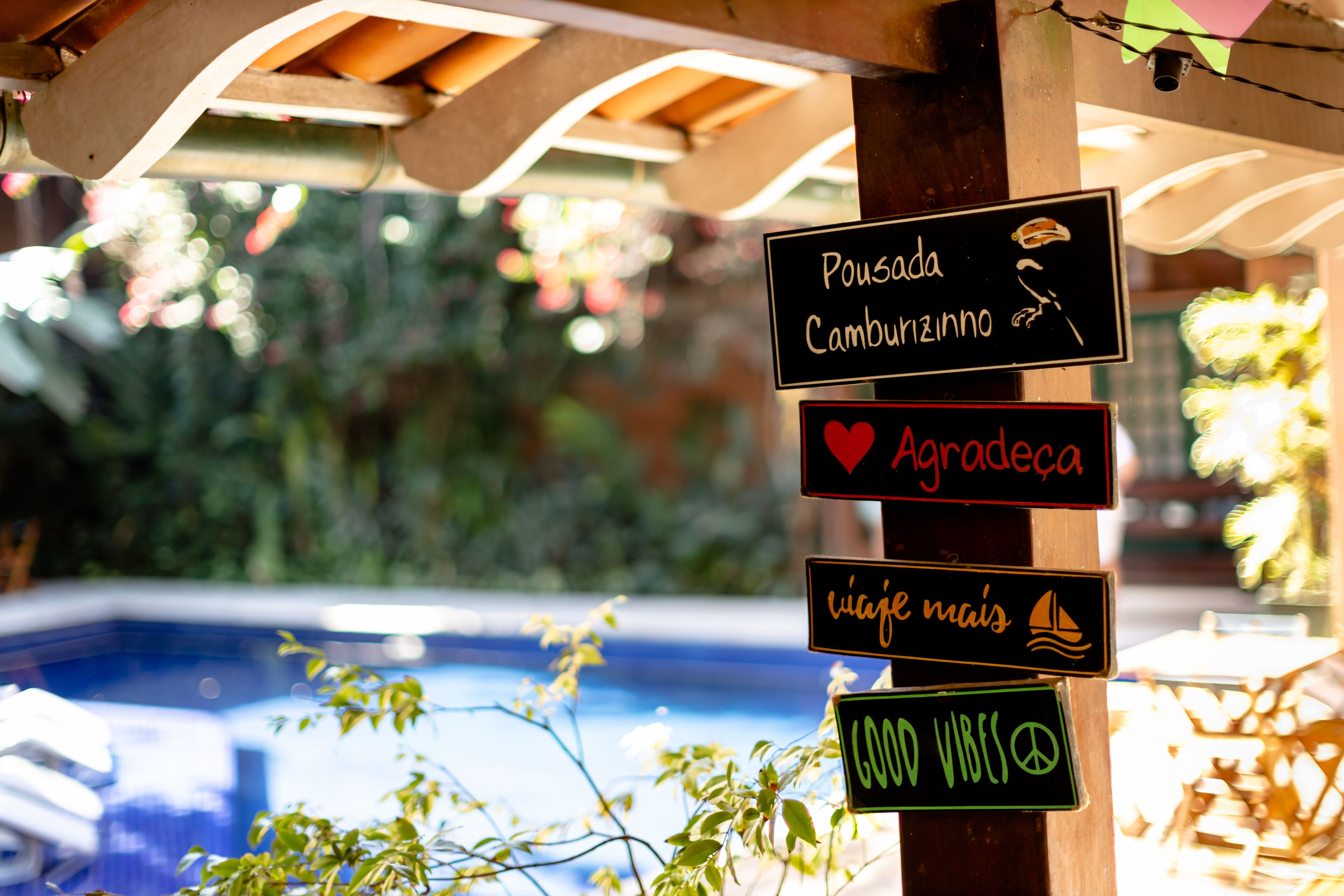 Um painel com vários destinos e símbolos, incluindo um coração e um veleiro, próximo a uma piscina.