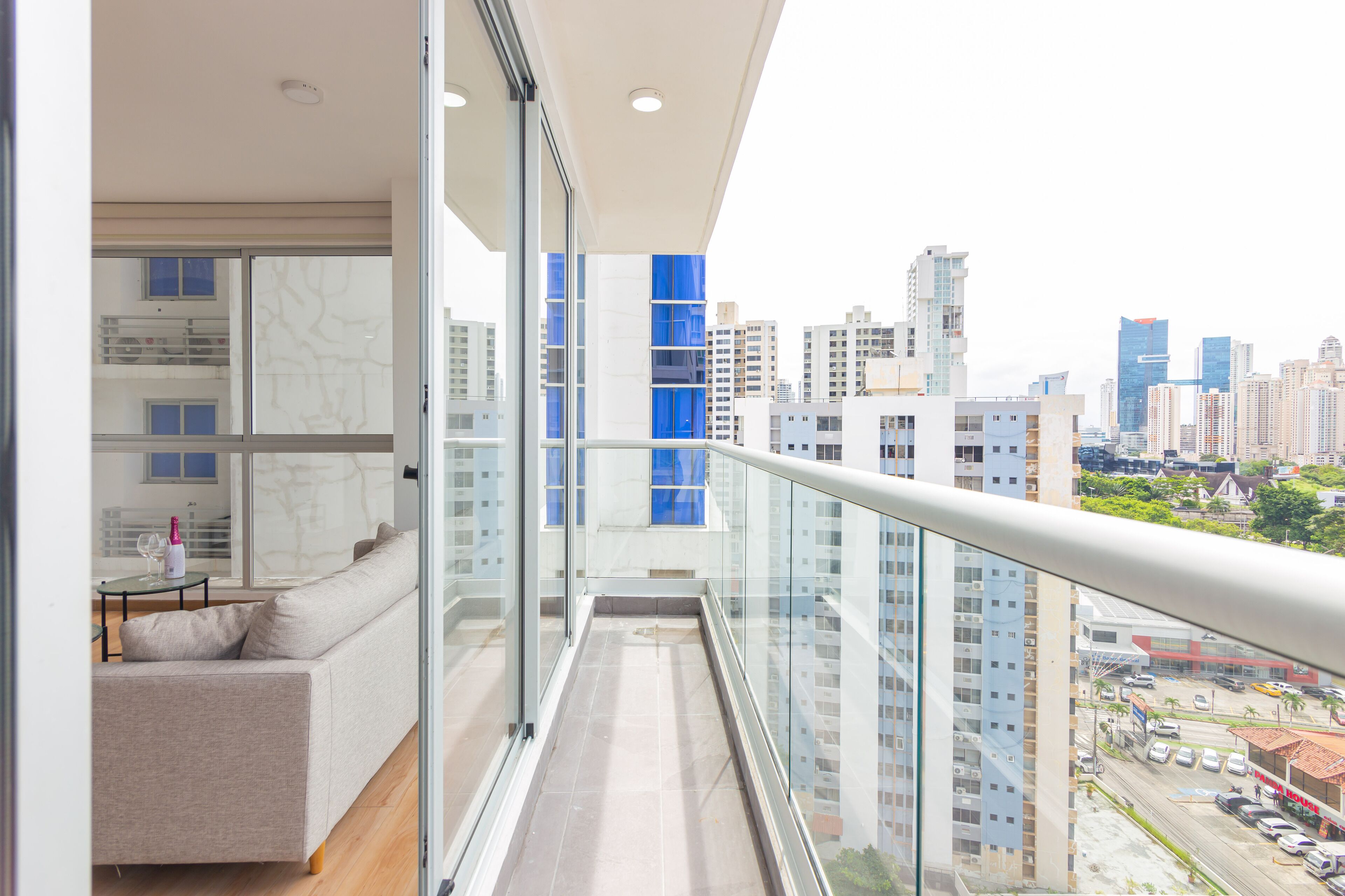Un appartement moderne doté d’un balcon, de grandes fenêtres et offrant une vue sur la ville.