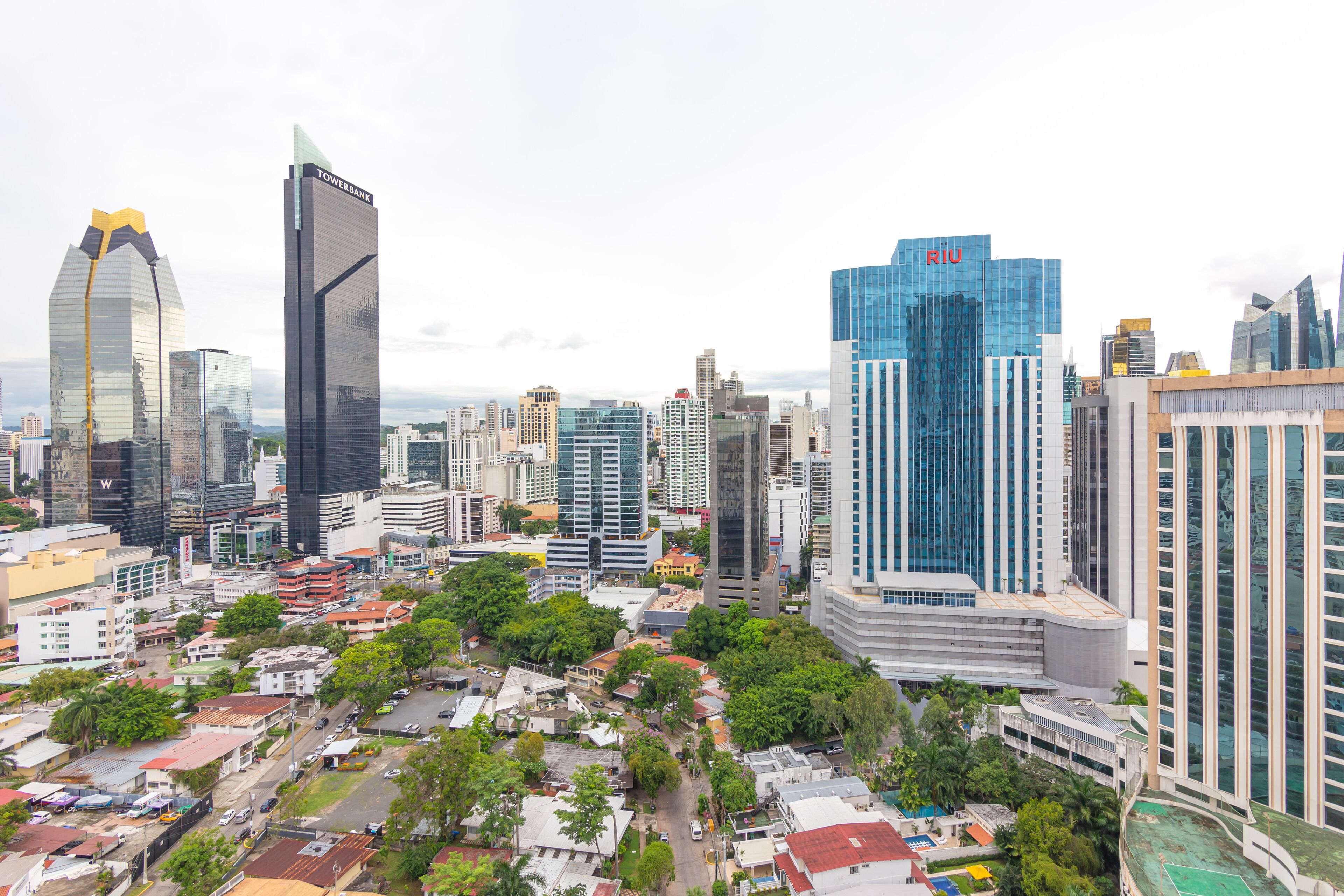Un paisaje urbano con modernos rascacielos, incluyendo una torre destacada con un diseño singular y un edificio con el rótulo "RIO".