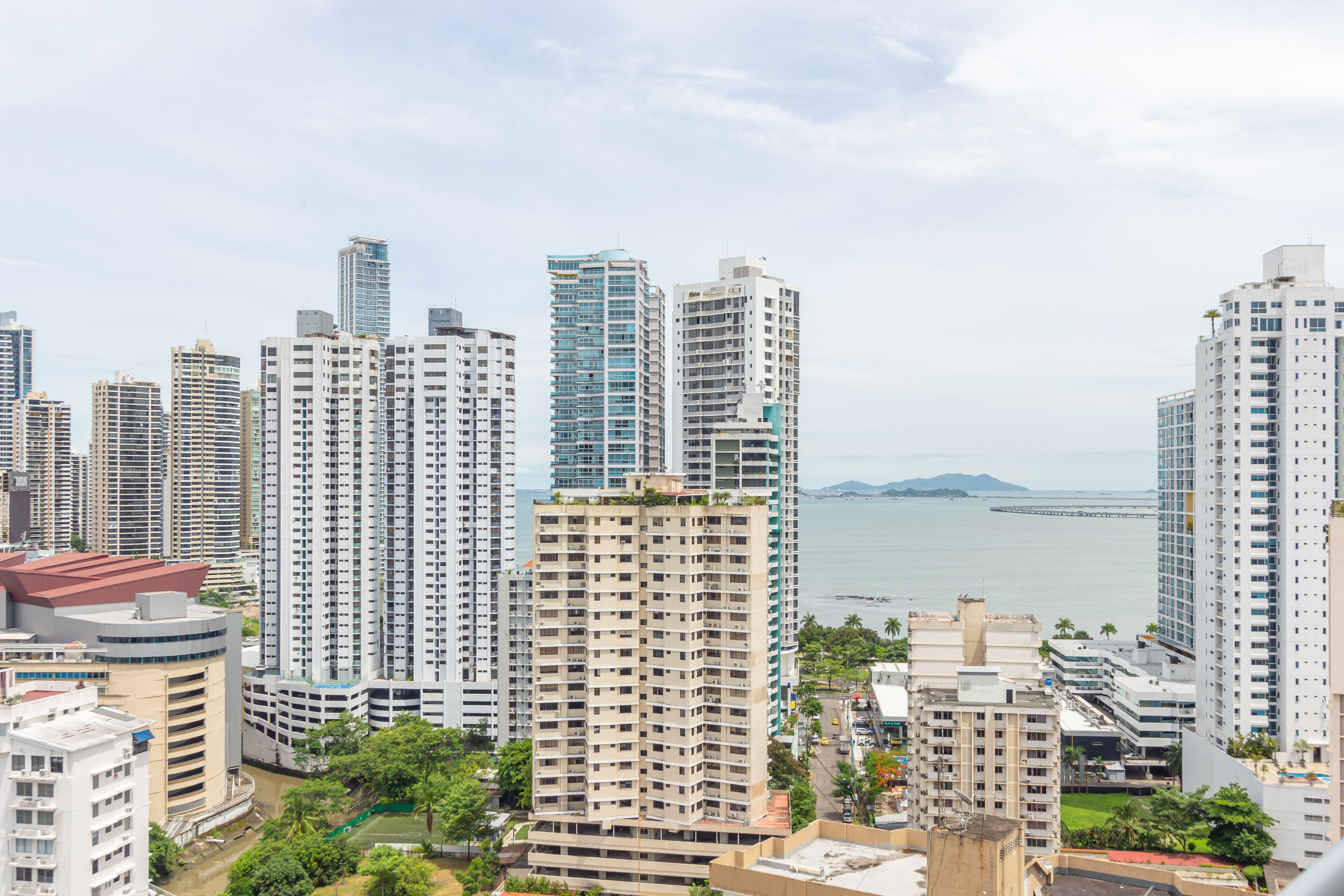 Un complejo de edificios residenciales de gran altura con varios edificios de apartamentos, un puerto deportivo y una isla distante.