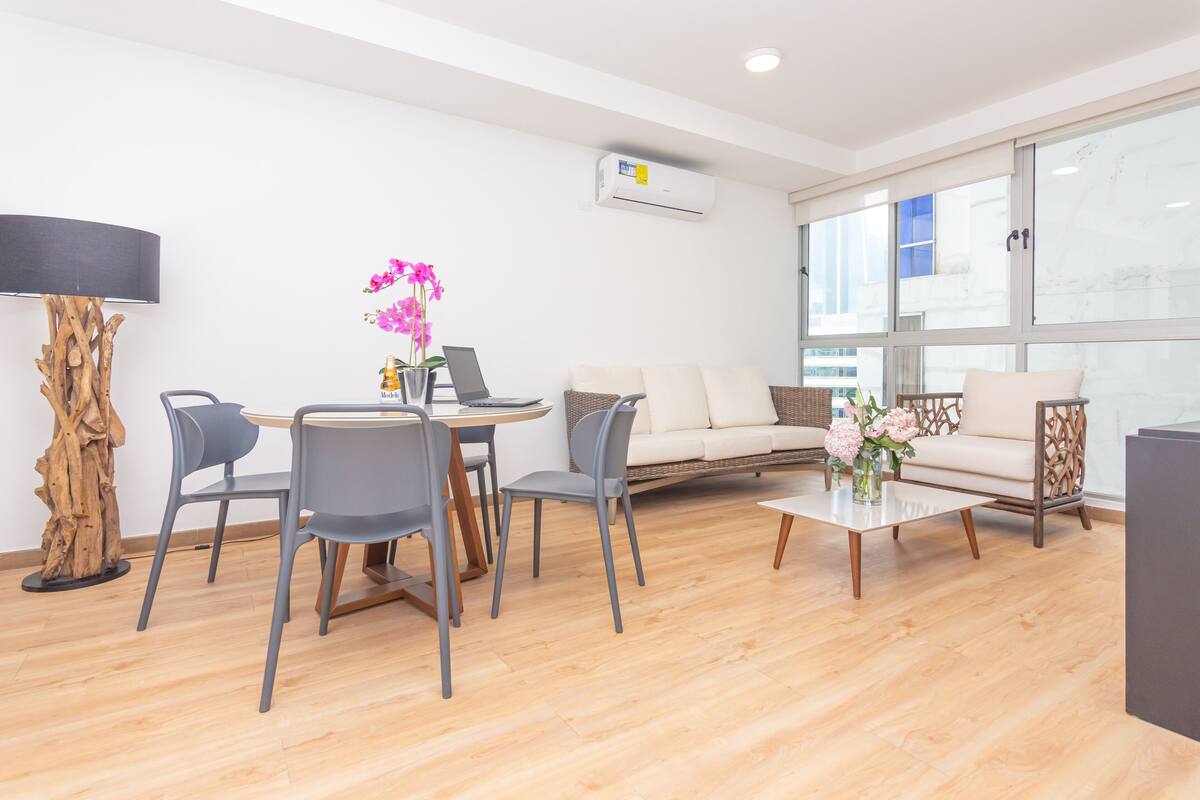 A modern living room with a dining area, a sofa, and a coffee table.