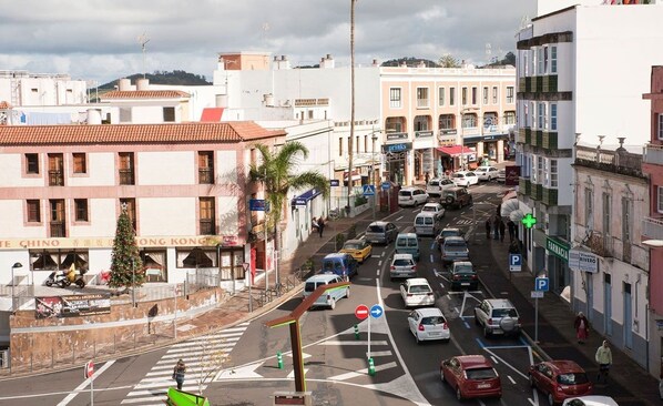 Une rue animée en milieu urbain, bordée d’immeubles, avec des voitures et des piétons.