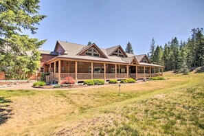 A large, two-story wooden house with a covered porch and multiple windows.