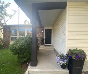 Welcome to a charming home with a cozy porch, complete with a black column and steps leading to the front door.