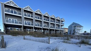 A multi-story hotel with balconies, located near a sandy beach. - Beachfront--Beachfront- Driftwood Yard (Mexico Beach)