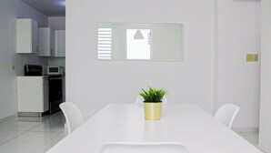 A modern kitchen with white cabinets, a microwave, and a sink. - Arecibo Hotel 2104 (Arecibo)