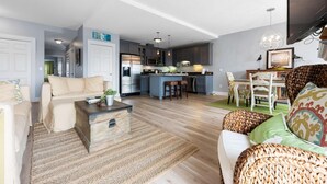 A modern living room with a sofa, coffee table, and a kitchen area with a bar.