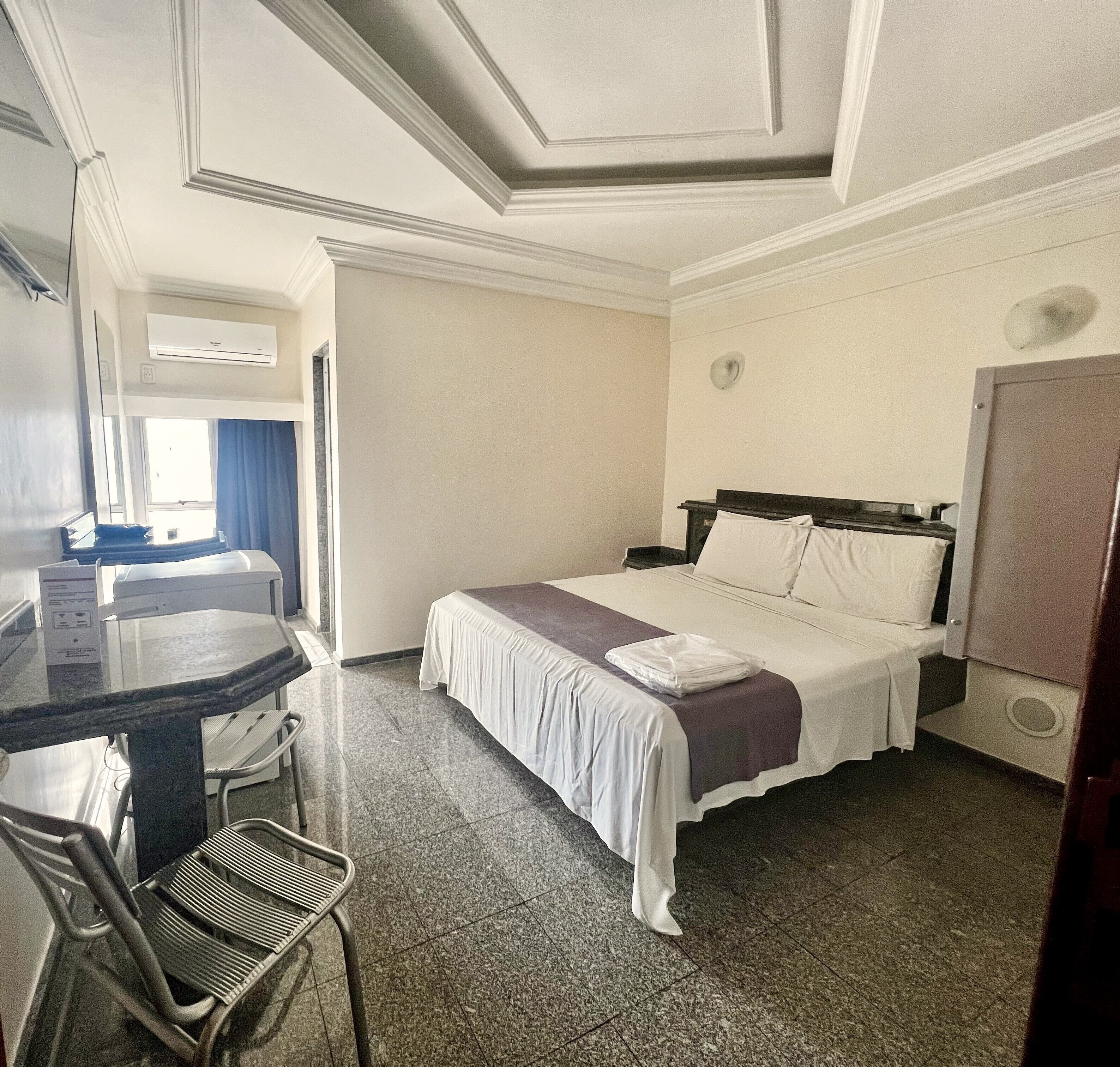 Een hotelkamer met een bed, een bureau en een stoel.