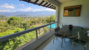 Ein Balkon mit Blick auf Berge und Grün.