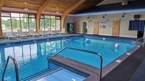 An indoor swimming pool with a wooden ceiling, clear glass windows, and a lifeguard warning sign. - Two Double Beds - Standard (Fairhaven)