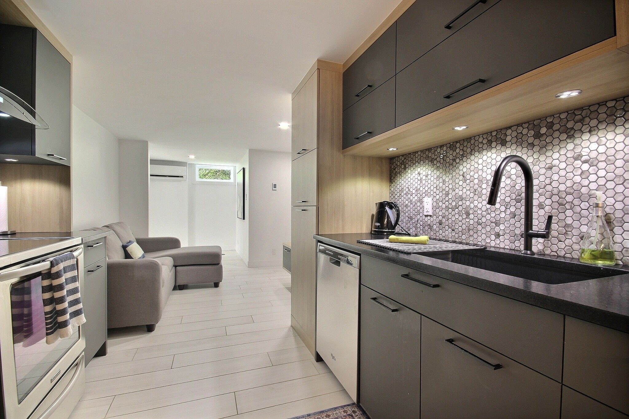 A modern kitchen with a built-in dishwasher, a coffee machine, and a sink with a black faucet.