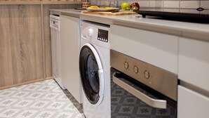 A modern kitchen with a built-in washing machine, a microwave, and a built-in oven.