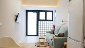 Un saló modern amb un sofà, una taula petita i una làmpada.