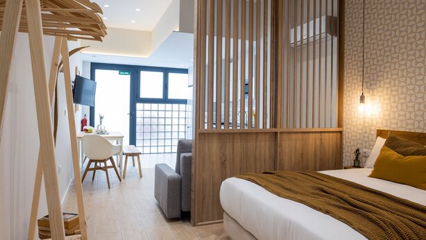 Een moderne hotelkamer met een bed, een bureau en een stoel.