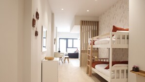 A modern, well-lit room with bunk beds, a small desk, and a chair. - The Sea Rooms I | AC & WIFI | 15 min Beach (Valencia)