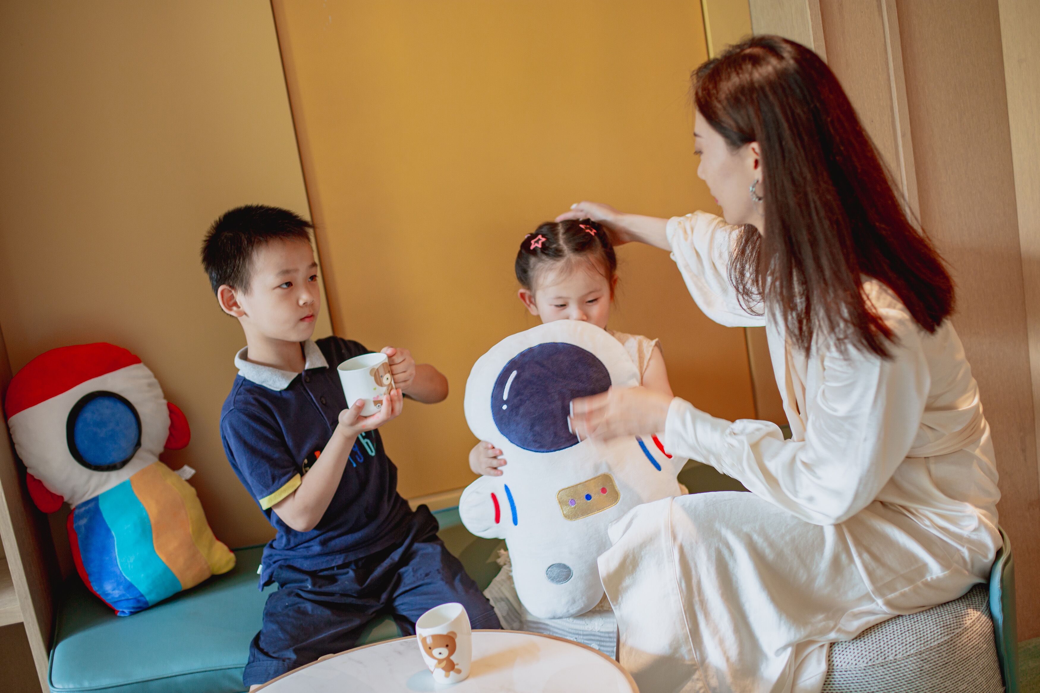 A room with a sofa, a table, and a child in astronaut costume.
