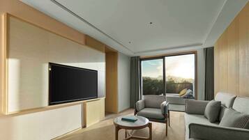 Una sala de estar moderna con un televisor de pantalla plana montado en la pared, un sofá, un sillón y una mesita.
