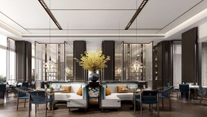 Un comedor moderno con disposición central de asientos, ventanas amplias y luminarias contemporáneas.