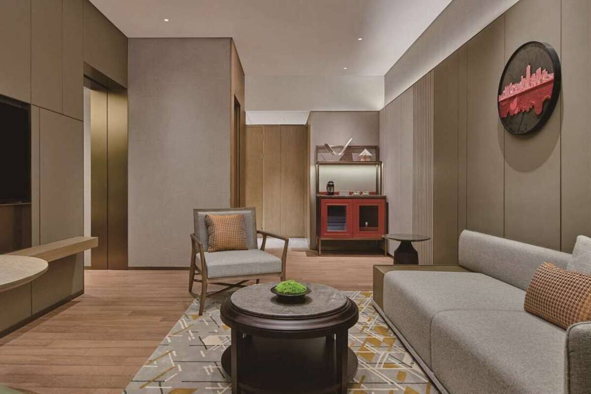 Un salon moderne avec un canapé, un fauteuil et une petite table sur laquelle se trouve un bol.