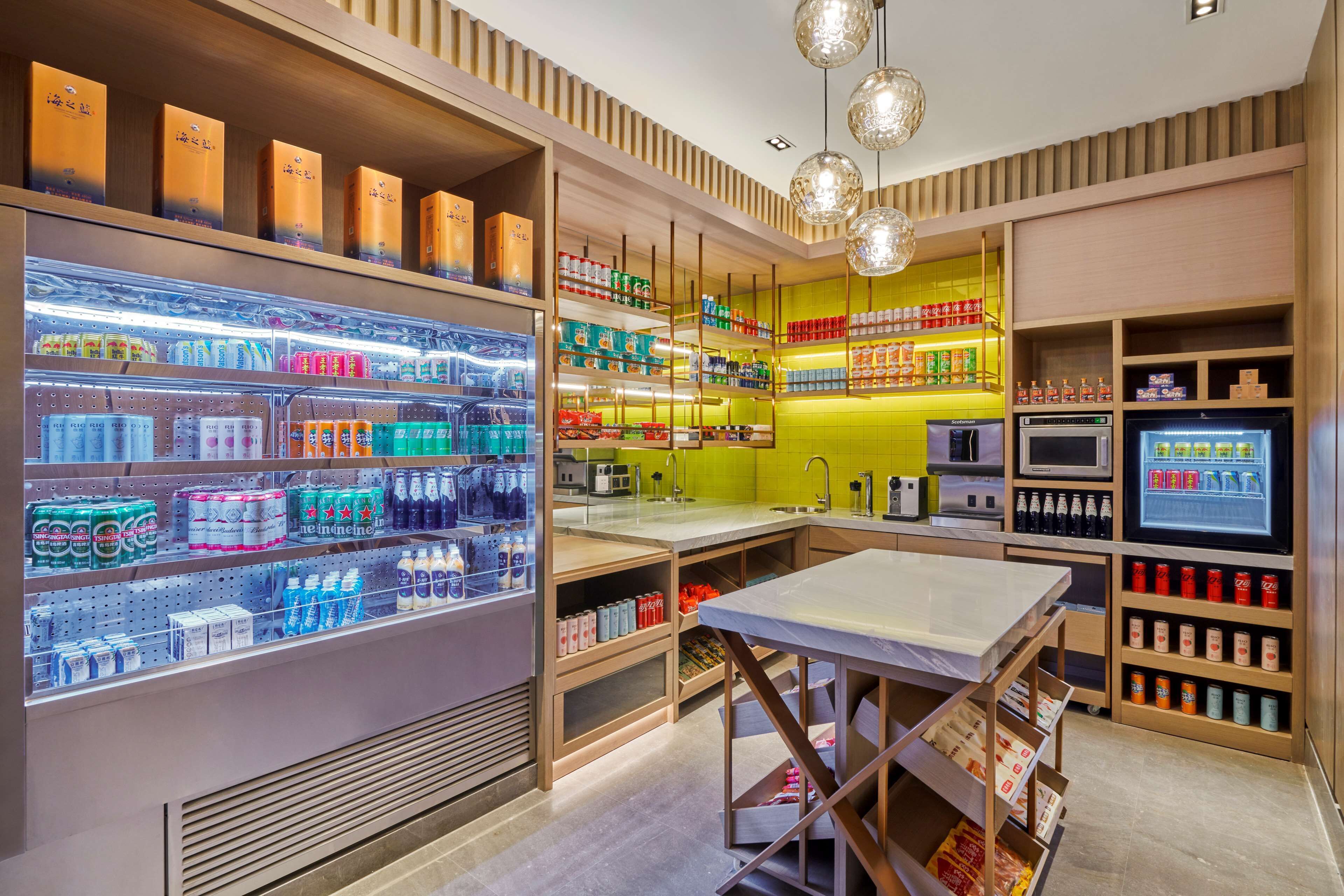 Un espacio comercial moderno con estantes llenos de diversas bebidas, un mostrador de exhibición y una sección refrigerada.