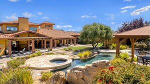 Un patio con piscina, mobiliario exterior y un porche cubierto.