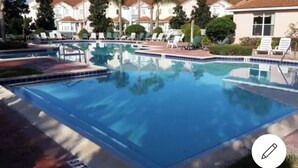 A swimming pool with lounge chairs and a building in the background. - 💖20 mins 2 Disney; 400Mbps WiFi; 2 Masters✔️Gated (Kissimmee)